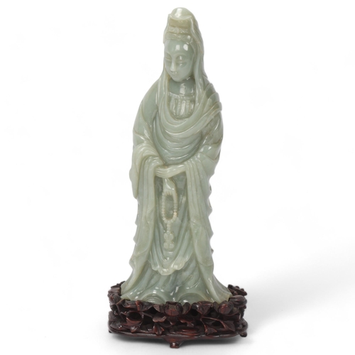 782 - A Chinese carved green jade figure of Guanyin on carved hardwood stand, overall height 32cm, provena... 