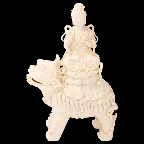 826 - A Chinese blanc de chine porcelain figure of Guanyin on a dog of fo, impressed seal and gourd mark t... 