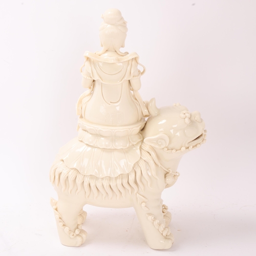 826 - A Chinese blanc de chine porcelain figure of Guanyin on a dog of fo, impressed seal and gourd mark t... 