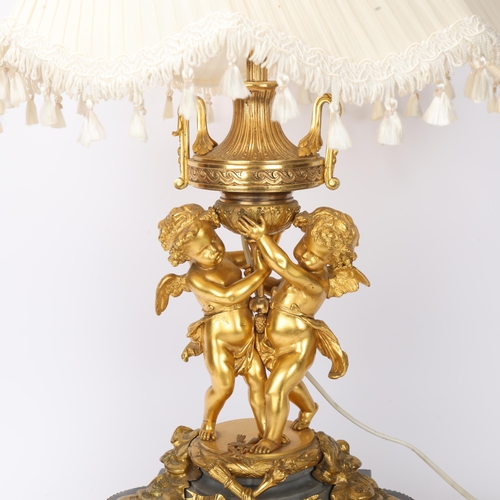 701 - An ornate French gilt-bronze table lamp, supported by 2 cherubs, probably late 19th century, on ormo... 