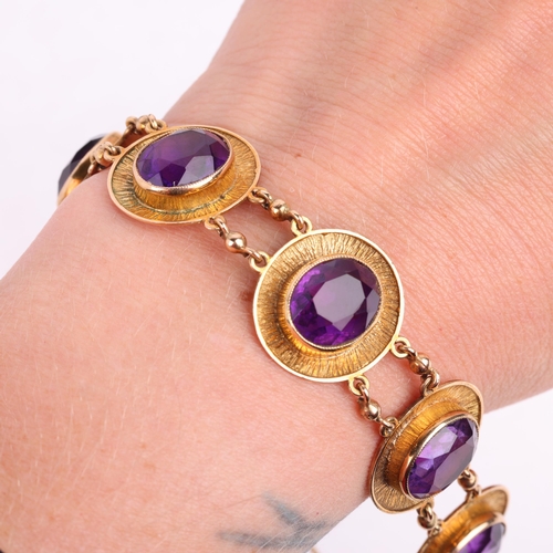 2121 - A 1970s 9ct gold amethyst panel bracelet, maker JR, Birmingham 1974, each oval panel rub-over set wi... 