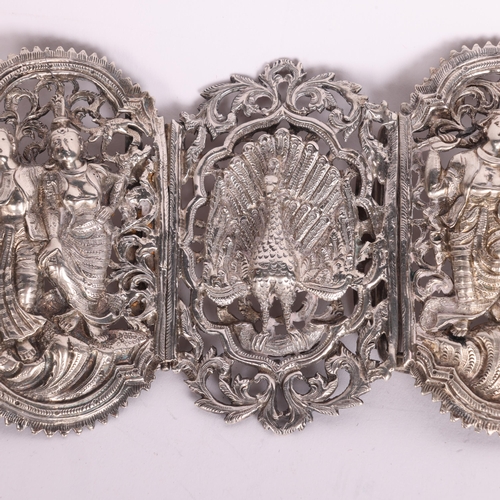 2699 - A large Indian silver nurse's buckle, relief embossed decoration depicting peacock and dancing figur... 