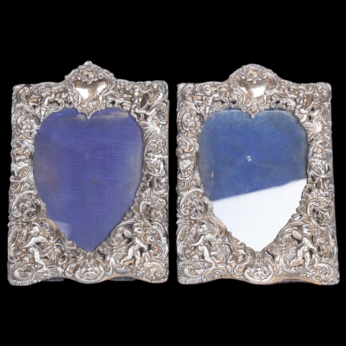 2705 - A pair of late Victorian silver-fronted heart photo frames, William Comyns, London 1892, relief embo... 