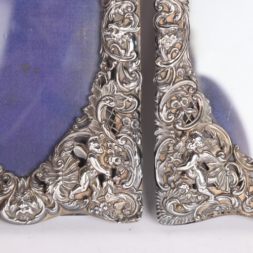 2705 - A pair of late Victorian silver-fronted heart photo frames, William Comyns, London 1892, relief embo... 