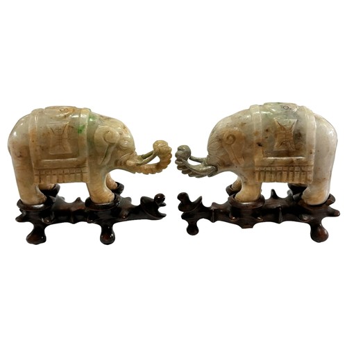 865 - A pair of small Chinese carved jade elephants on carved wood stands, length 10.5cm