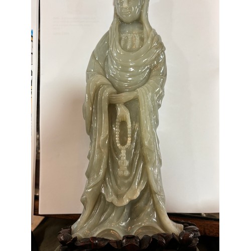 782 - A Chinese carved green jade figure of Guanyin on carved hardwood stand, overall height 32cm, provena... 