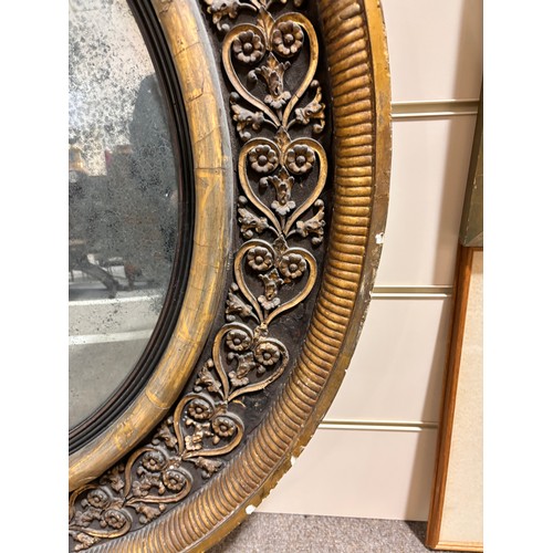 891 - A large Georgian convex mirror, with gilded relief carved wood and gesso surround, original oxidised... 