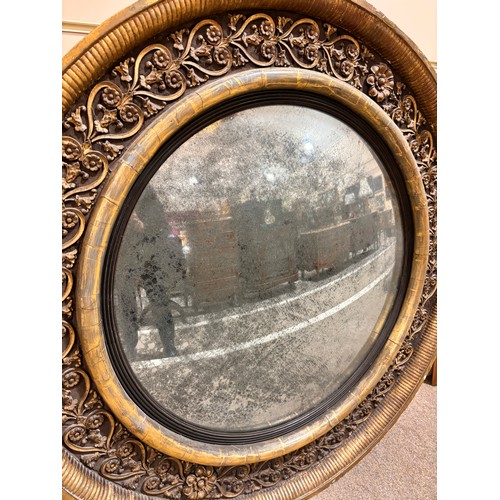 891 - A large Georgian convex mirror, with gilded relief carved wood and gesso surround, original oxidised... 