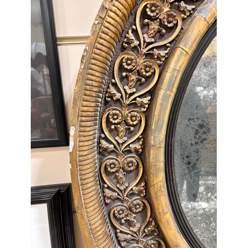 891 - A large Georgian convex mirror, with gilded relief carved wood and gesso surround, original oxidised... 