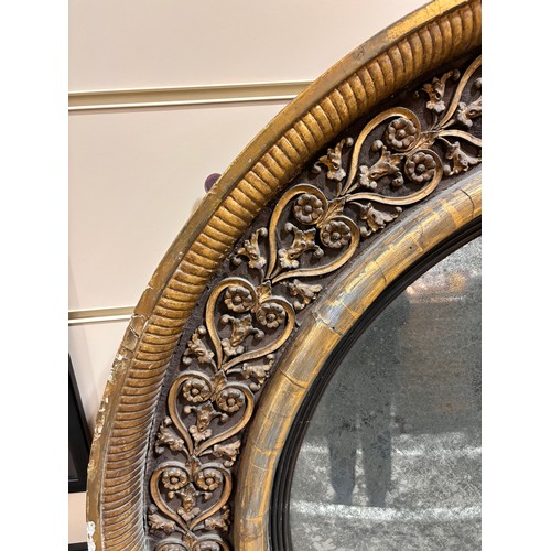 891 - A large Georgian convex mirror, with gilded relief carved wood and gesso surround, original oxidised... 