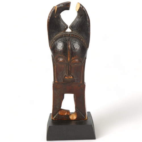 48 - A Baule, Ivory Coast weaving pulley, carved wood masked figure on wooden plinth, height 16cm