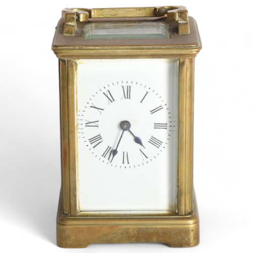 100 - A brass-cased carriage clock, with white enamel dial and Roman numerals, H11cm not including handle