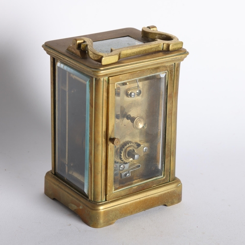 100 - A brass-cased carriage clock, with white enamel dial and Roman numerals, H11cm not including handle