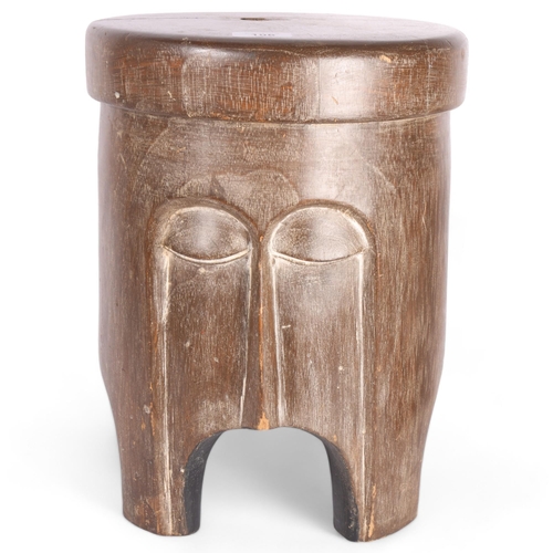 106 - An African Tribal carved wood trunk stool, with stylised facial body, diameter 28cm, height 36cm