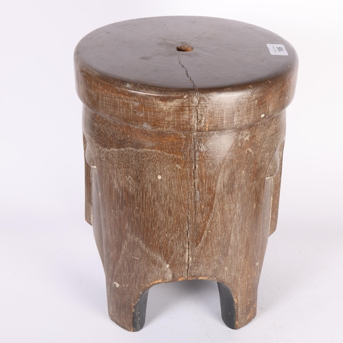 106 - An African Tribal carved wood trunk stool, with stylised facial body, diameter 28cm, height 36cm