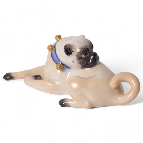 2 - Meissen, a porcelain figure of a seated Pug looking backwards, with a blue and gilded studded collar... 