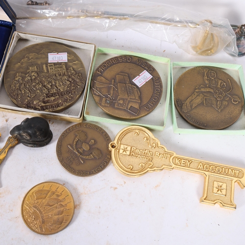 214 - A collection of various souvenir plaques and medallions, including Castello De Leirit, angel wind ch... 