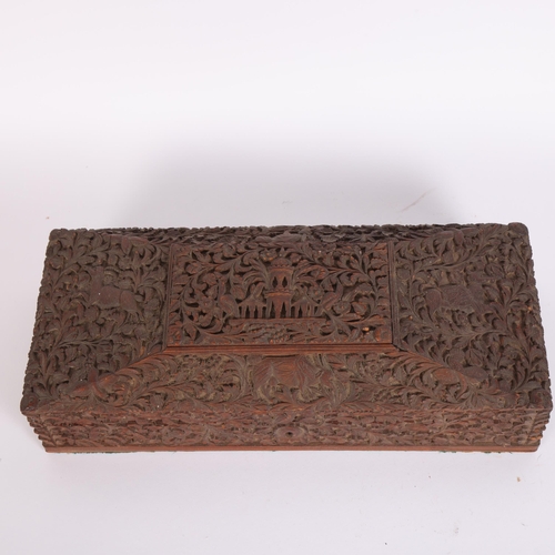 231 - An Anglo-Indian sandalwood box, with intricate carved decoration, temple scene to main panel with va... 