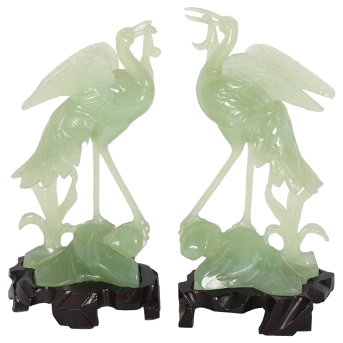 550 - A pair of jadeite wading birds, on fitted carved wood plinths, H23cm