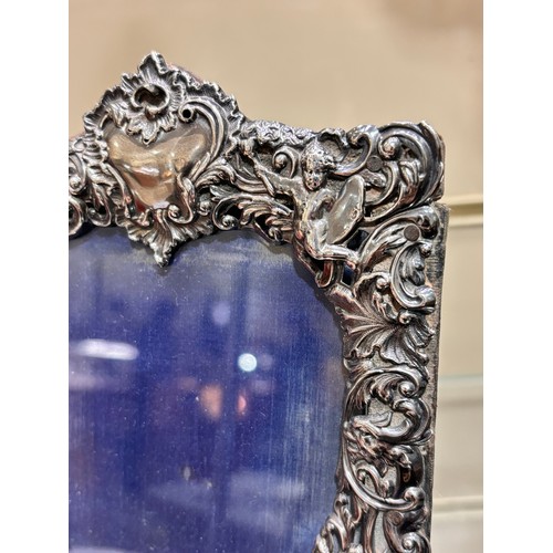 2705 - A pair of late Victorian silver-fronted heart photo frames, William Comyns, London 1892, relief embo... 