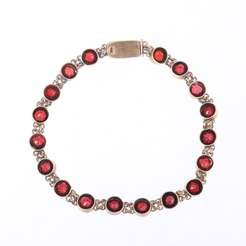 1118 - An Austro-Hungarian 14ct gold? garnet tennis line bracelet, circa 1900, millegrain set with round fa... 