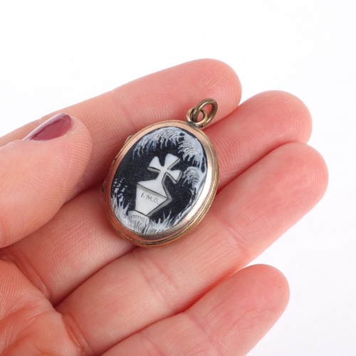 1122 - A Victorian monochrome enamel 'In Memory Of' mourning locket pendant, the front panel having hand pa... 