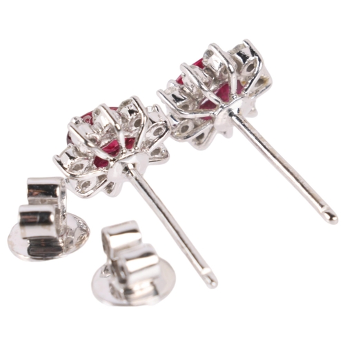 1148 - A pair of 18ct white gold ruby and diamond flowerhead cluster earrings, set with oval mixed-cut rubi... 