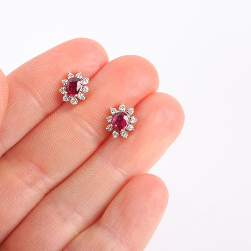 1148 - A pair of 18ct white gold ruby and diamond flowerhead cluster earrings, set with oval mixed-cut rubi... 