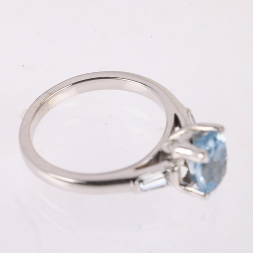 1161 - An 18ct white gold blue topaz and diamond ring, claw set with oval mixed-cut blue topaz, flanked by ... 