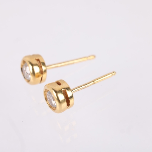 1183 - A pair of 18ct gold 0.6ct single stone diamond earrings, maker PH, each rub-over set with 0.3ct mode... 