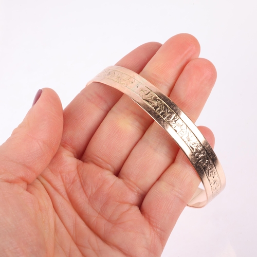 1189 - An Antique 9ct rose gold slave bangle, indistinct maker, floral engraved decoration, band width 11mm... 