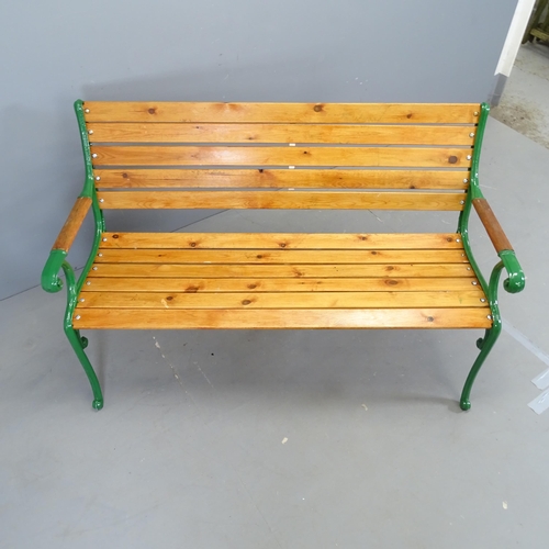 3031 - A stained pine slatted garden bench with painted cast iron ends. 136x82x64cm.