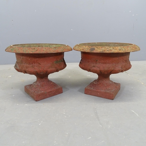 3043 - A pair of painted cast iron urns. 32x24cm.