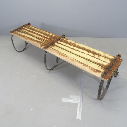 3051 - A folding slatted and iron framed garden bench. 180x82x52cm.