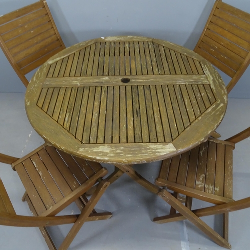 3058 - A teak circular top folding garden table, 109x74cm, and four matching chairs.