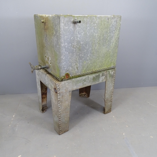 3073 - A galvanised metal water tank on stand. Overall (including tap) 90x116x57cm.