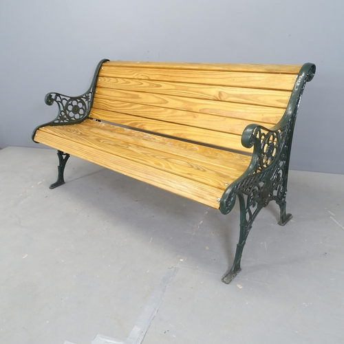 3077 - A stained pine slatted garden bench with painted cast iron ends. 142x75x65cm.