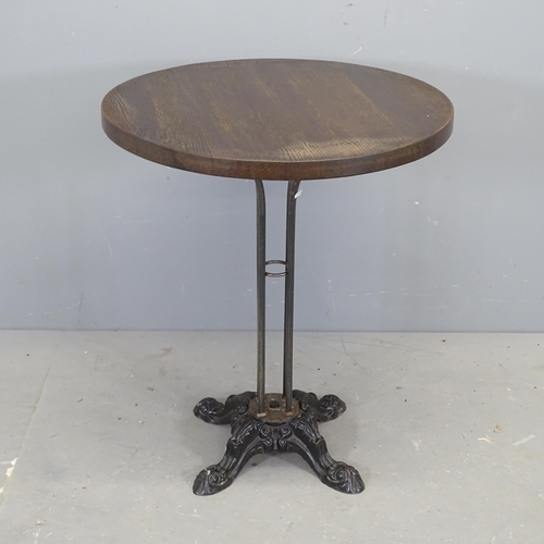 3101 - An oak circular-topped bistro table on painted cast iron base. 61x71cm.