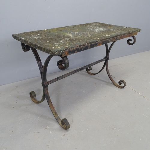 3110 - A weathered stone topped garden table on wrought iron base. 86x56x47cm.