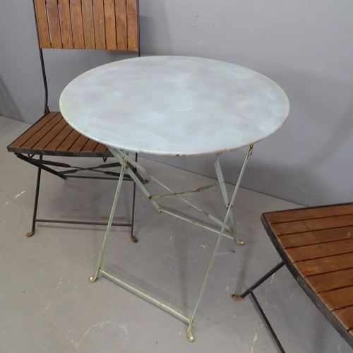 3162 - A modern circular folding painted metal garden table, 60x71cm, and two folding chairs.