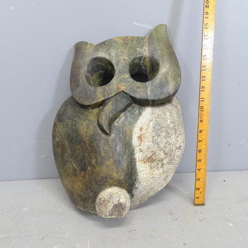 3221 - A hand carved serpentine sculpture, study of an owl. Height 50cm.