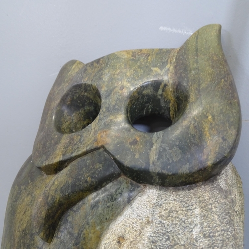 3221 - A hand carved serpentine sculpture, study of an owl. Height 50cm.