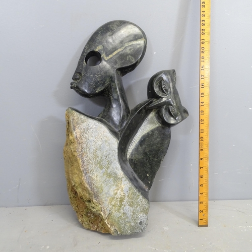 3223 - A hand carved hardstone sculpture, study of a man and owl. Height 63cm.