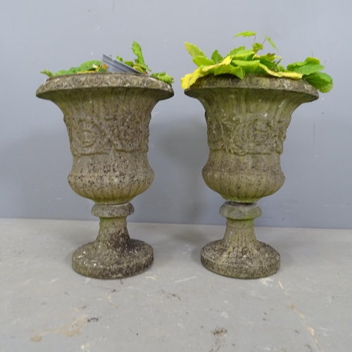 3349 - A pair of small weathered concrete fluted urns on stands. 33x45cm.