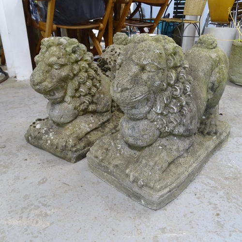 3387 - A pair of weathered stone recumbant lion sculptures. 63x42x29cm.