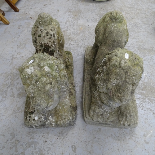 3387 - A pair of weathered stone recumbant lion sculptures. 63x42x29cm.