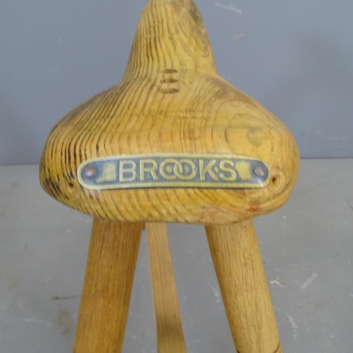 3420 - A handmade bicycle seat design stool on tripod base, by local artist Clive Fredriksson. Height 59cm.