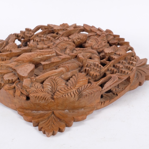 109 - An intricately carved wood Balinese Rama and Sita couple wall plaque, diameter 29cm