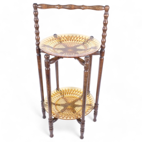 115 - A 1920s oak 2-tier folding cake stand, with amber glass plates, H69cm