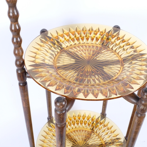 115 - A 1920s oak 2-tier folding cake stand, with amber glass plates, H69cm